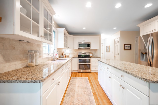 45 Wolf Pit Rd, Southbury, CT 06488 - kitchen with appliances with stainless steel finishes, a sink, light wood finished floors, backsplash, and light stone countertops