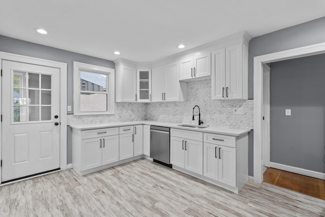 181 Westbourne Pkwy, Hartford, CT 06112 - kitchen featuring a sink, dishwasher, decorative backsplash, light countertops, and light wood-style floors