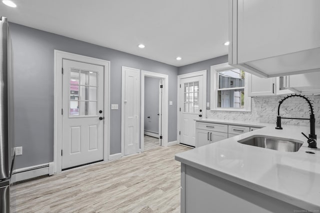 181 Westbourne Pkwy, Hartford, CT 06112 - kitchen with light wood-style flooring, recessed lighting, a baseboard heating unit, a sink, and light countertops