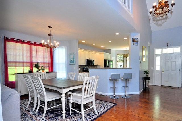 dining area featuring recessed lighting, baseboards, an inviting chandelier, and dark wood-style floors