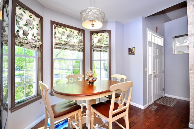 dining area featuring baseboards, dark wood-style flooring, and visible vents