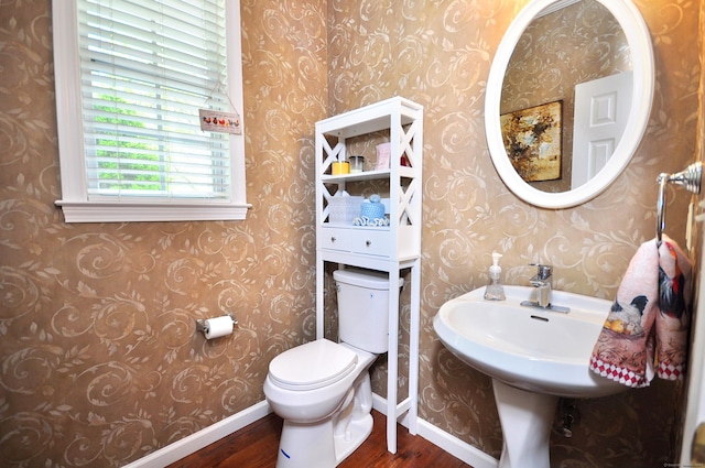 bathroom with baseboards, wood finished floors, toilet, and wallpapered walls