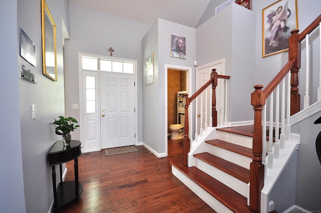 foyer entrance featuring stairway, high vaulted ceiling, baseboards, and dark wood-style flooring