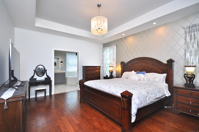 bedroom with an accent wall, baseboards, wallpapered walls, a chandelier, and dark wood finished floors