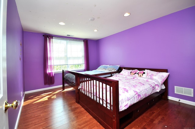 bedroom with baseboards, recessed lighting, wood finished floors, and visible vents