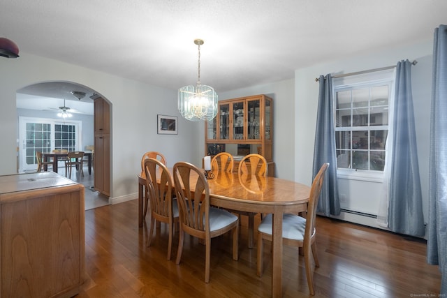 dining room featuring ceiling fan with notable chandelier, wood-type flooring, and arched walkways