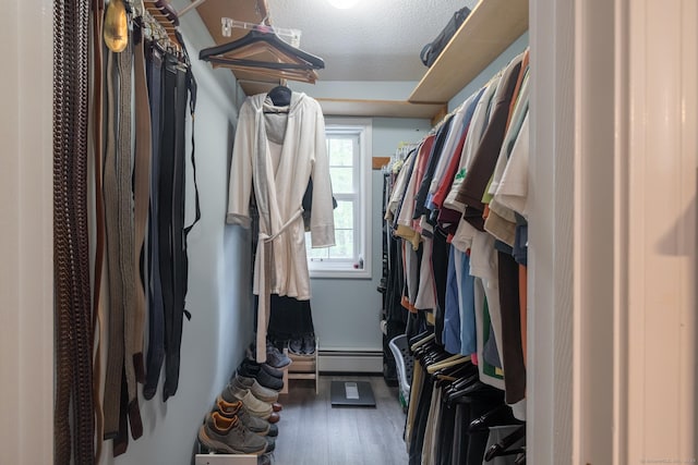 spacious closet with baseboard heating and wood finished floors