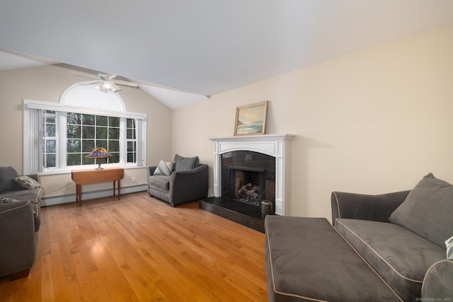 living room featuring a premium fireplace, a baseboard heating unit, light wood finished floors, ceiling fan, and vaulted ceiling