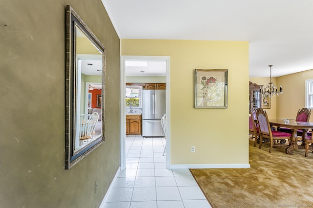 250 Glenn Dr, Stratford, CT 06614 - corridor with a chandelier, baseboards, and light tile patterned flooring