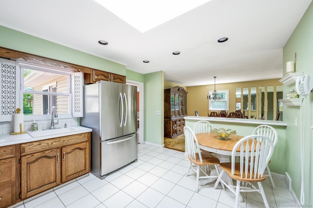 250 Glenn Dr, Stratford, CT 06614 - kitchen featuring freestanding refrigerator, a sink, brown cabinetry, a chandelier, and recessed lighting