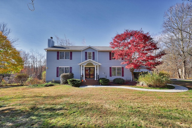 view of front of property with a chimney and a front lawn