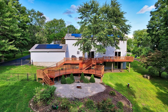 back of house featuring a yard, solar panels, stairs, a deck, and a fenced backyard