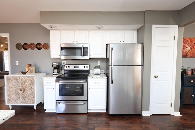 kitchen with appliances with stainless steel finishes, dark wood-style flooring, and white cabinetry