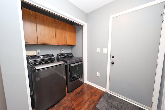 washroom with baseboards, washer and clothes dryer, cabinet space, and dark wood-type flooring