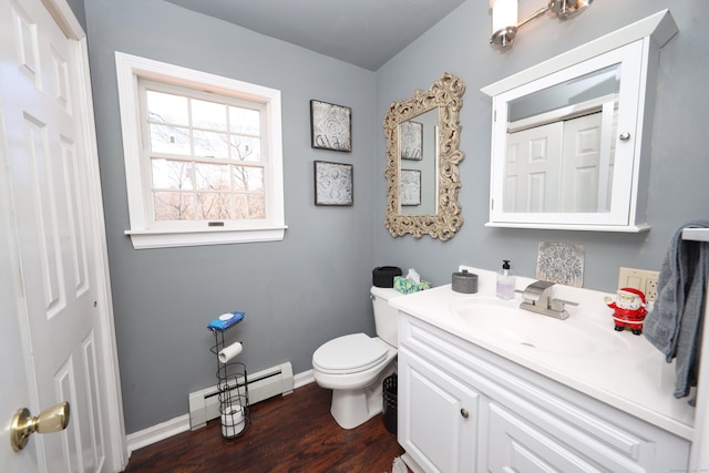 bathroom featuring a baseboard heating unit, baseboards, toilet, vanity, and wood finished floors