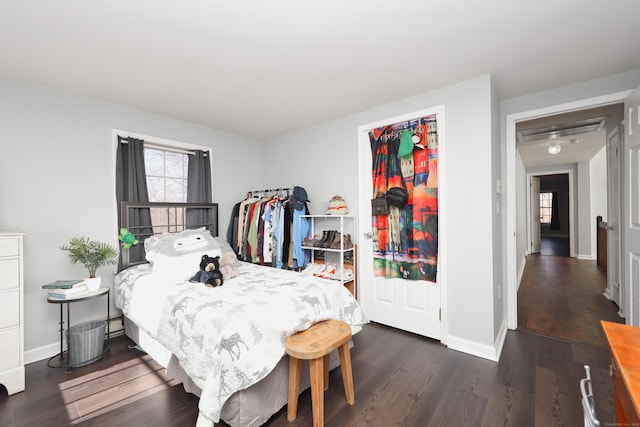 bedroom with baseboards and dark wood-type flooring