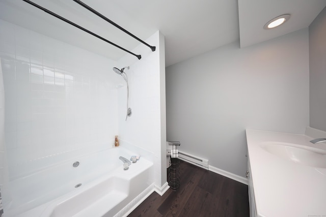 bathroom featuring wood finished floors, shower / bathing tub combination, baseboards, baseboard heating, and vanity