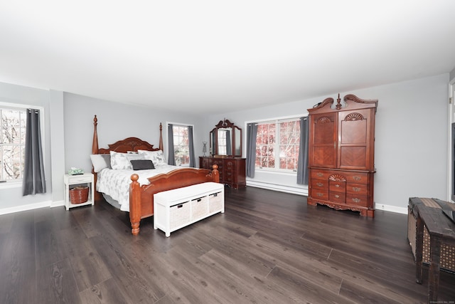 bedroom with dark wood-type flooring and baseboards