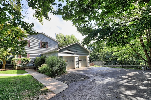 view of home's exterior with fence and driveway