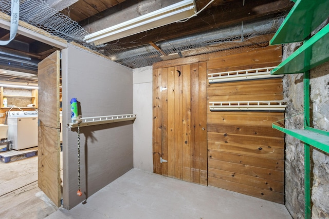 unfinished below grade area with washer / clothes dryer and wood walls