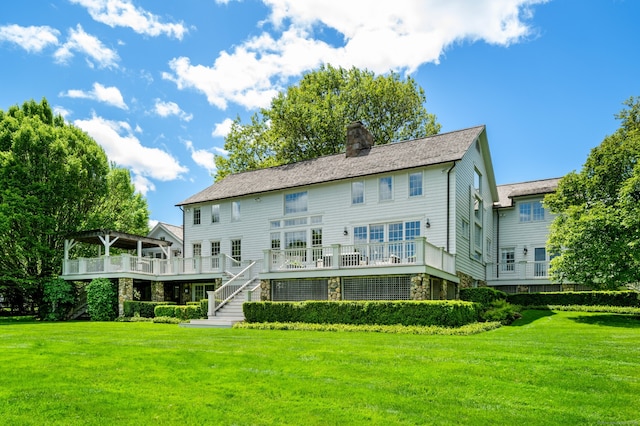 945 Oenoke Rdg, New Canaan, CT 06840 - rear view of property featuring a wooden deck, a chimney, a lawn, and stone siding