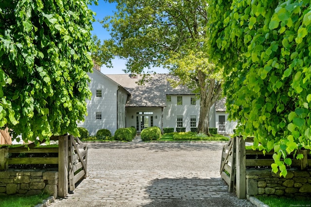 945 Oenoke Rdg, New Canaan, CT 06840 - view of front of house with french doors, roof with shingles, and a chimney