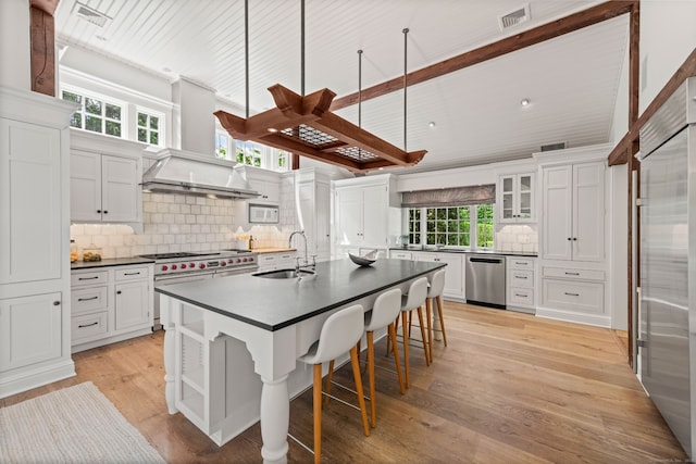 945 Oenoke Rdg, New Canaan, CT 06840 - kitchen with a sink, premium appliances, wall chimney range hood, dark countertops, and white cabinets