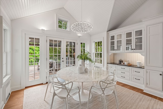 945 Oenoke Rdg, New Canaan, CT 06840 - dining area with lofted ceiling, french doors, radiator heating unit, a chandelier, and light wood-type flooring