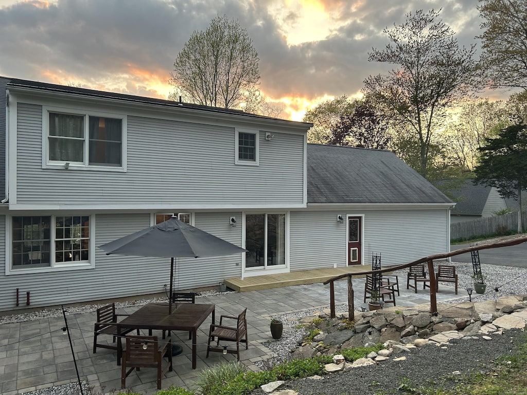 rear view of property featuring a wooden deck and a patio