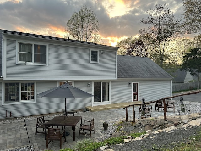 rear view of property featuring a wooden deck and a patio