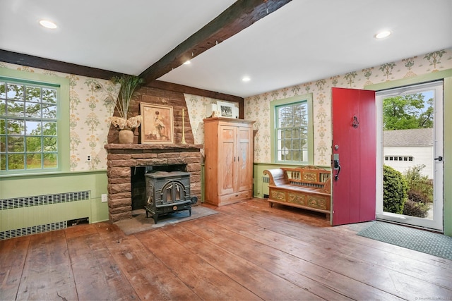 455 E St, Middletown, CT 06457 - living area with radiator, wallpapered walls, a wood stove, wood-type flooring, and beam ceiling
