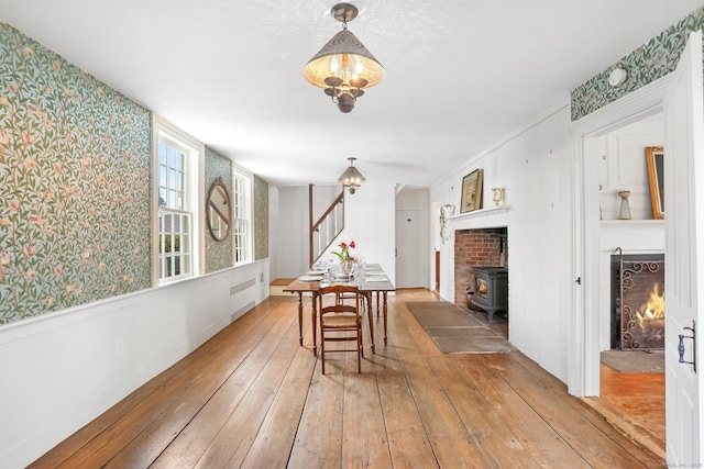 455 E St, Middletown, CT 06457 - dining area with light wood-style floors, wallpapered walls, stairway, a wood stove, and radiator heating unit