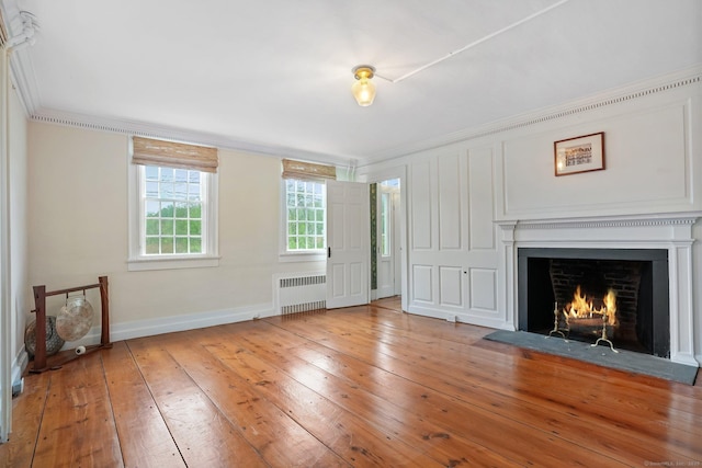 455 E St, Middletown, CT 06457 - unfurnished living room featuring radiator heating unit, ornamental molding, wood-type flooring, baseboards, and a fireplace with flush hearth