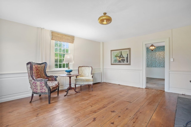455 E St, Middletown, CT 06457 - living area with radiator, wainscoting, light wood finished floors, and a decorative wall