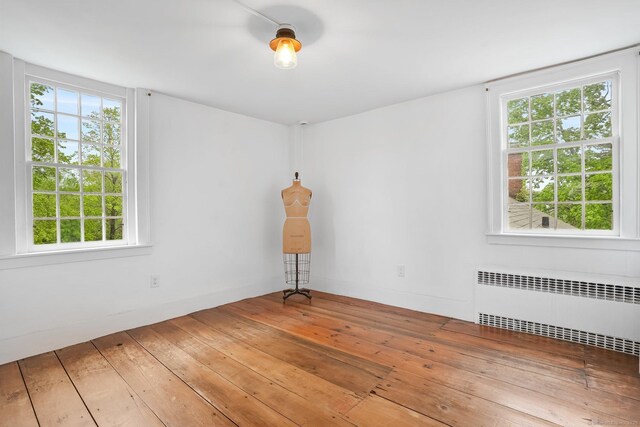 455 E St, Middletown, CT 06457 - empty room featuring radiator heating unit, hardwood / wood-style flooring, and healthy amount of natural light