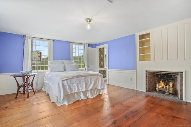 455 E St, Middletown, CT 06457 - bedroom featuring hardwood / wood-style floors, a fireplace with flush hearth, wainscoting, and baseboards