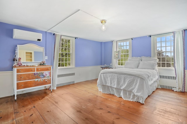 455 E St, Middletown, CT 06457 - bedroom with radiator heating unit, a wall mounted AC, wood-type flooring, and a wainscoted wall