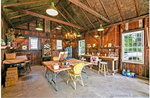 455 E St, Middletown, CT 06457 - dining area with wood walls, vaulted ceiling, a chandelier, and concrete flooring