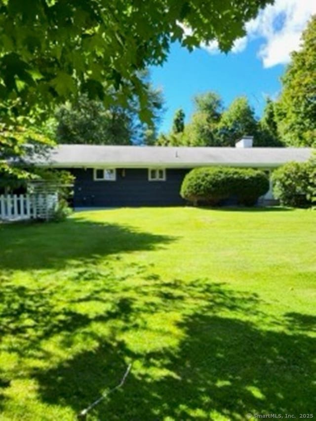 exterior space featuring fence and a front yard