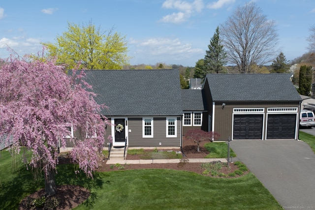 view of front of home featuring a garage, a shingled roof, asphalt driveway, and a front lawn