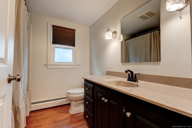 bathroom featuring baseboard heating, vanity, wood finished floors, and toilet