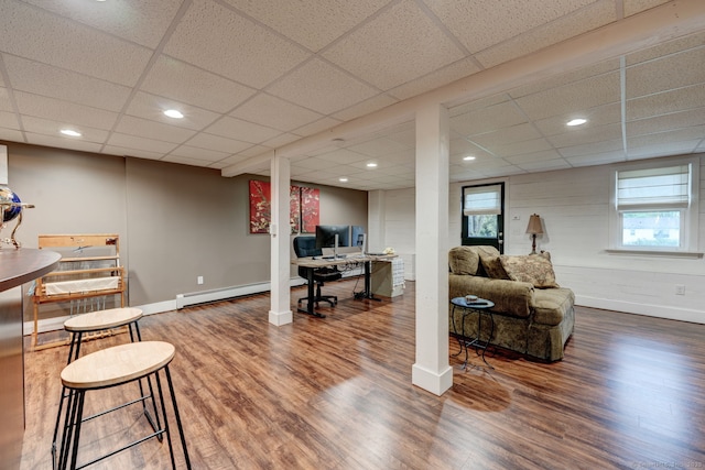 office area featuring wood finished floors, a paneled ceiling, a baseboard radiator, baseboards, and recessed lighting