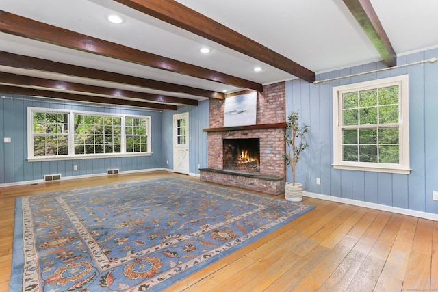 2 Kramer Ln, Weston, CT 06883 - unfurnished living room featuring beamed ceiling, hardwood / wood-style flooring, healthy amount of natural light, and a brick fireplace