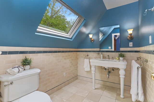 2 Kramer Ln, Weston, CT 06883 - half bath with tile walls, lofted ceiling, tile patterned floors, a skylight, and wainscoting