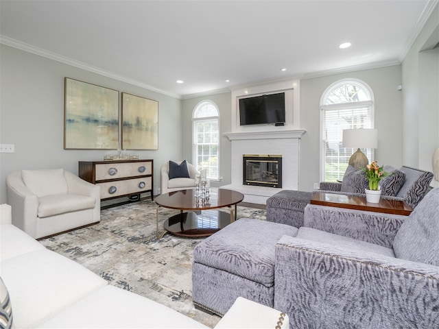 living room with ornamental molding, a brick fireplace, wood finished floors, and recessed lighting