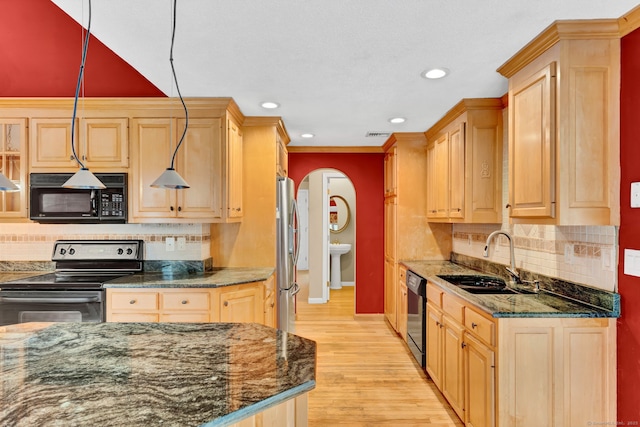 kitchen with black appliances, a sink, light brown cabinetry, arched walkways, and recessed lighting