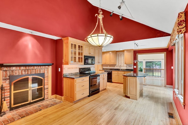 kitchen featuring black appliances, a sink, high vaulted ceiling, track lighting, and dark countertops