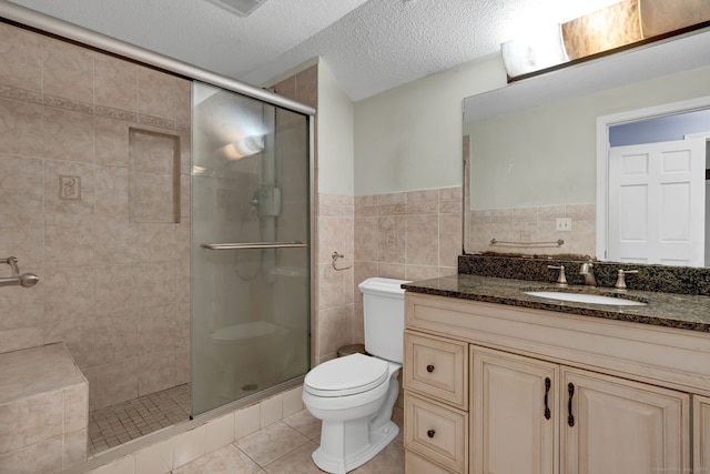 full bathroom with toilet, a shower stall, vanity, tile patterned floors, and a textured ceiling