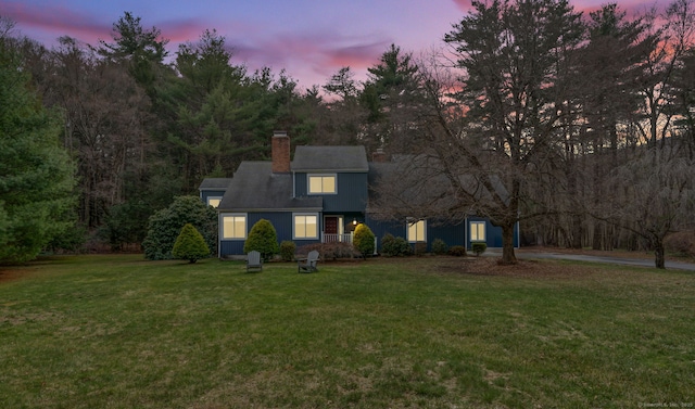 view of front of house with a lawn and a chimney