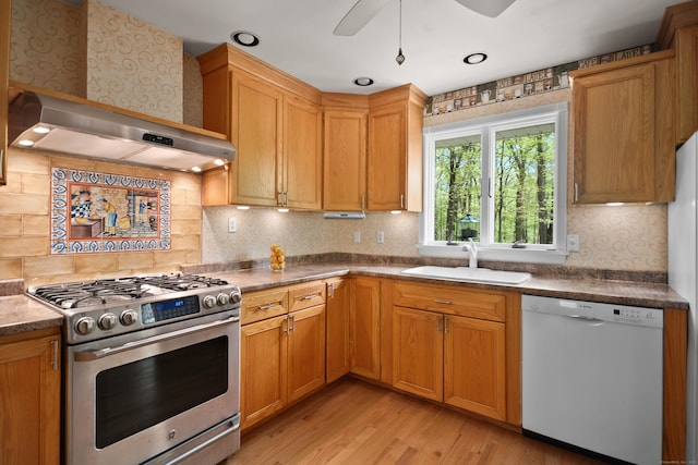 kitchen featuring light wood-style flooring, a sink, stainless steel gas stove, tasteful backsplash, and white dishwasher